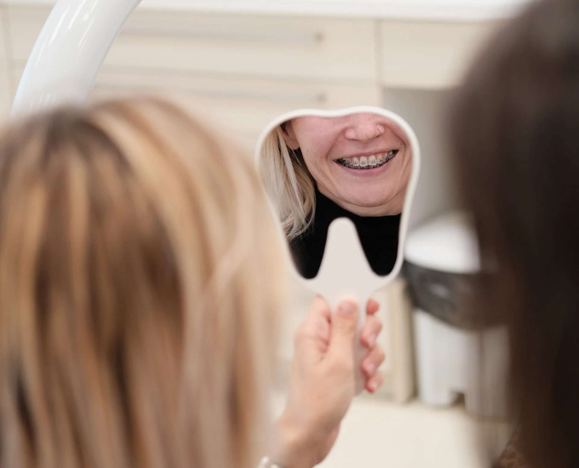 Páciens a fogszabályozó készülékét nézi tükörben az Orim Dental pécsi rendelőjében