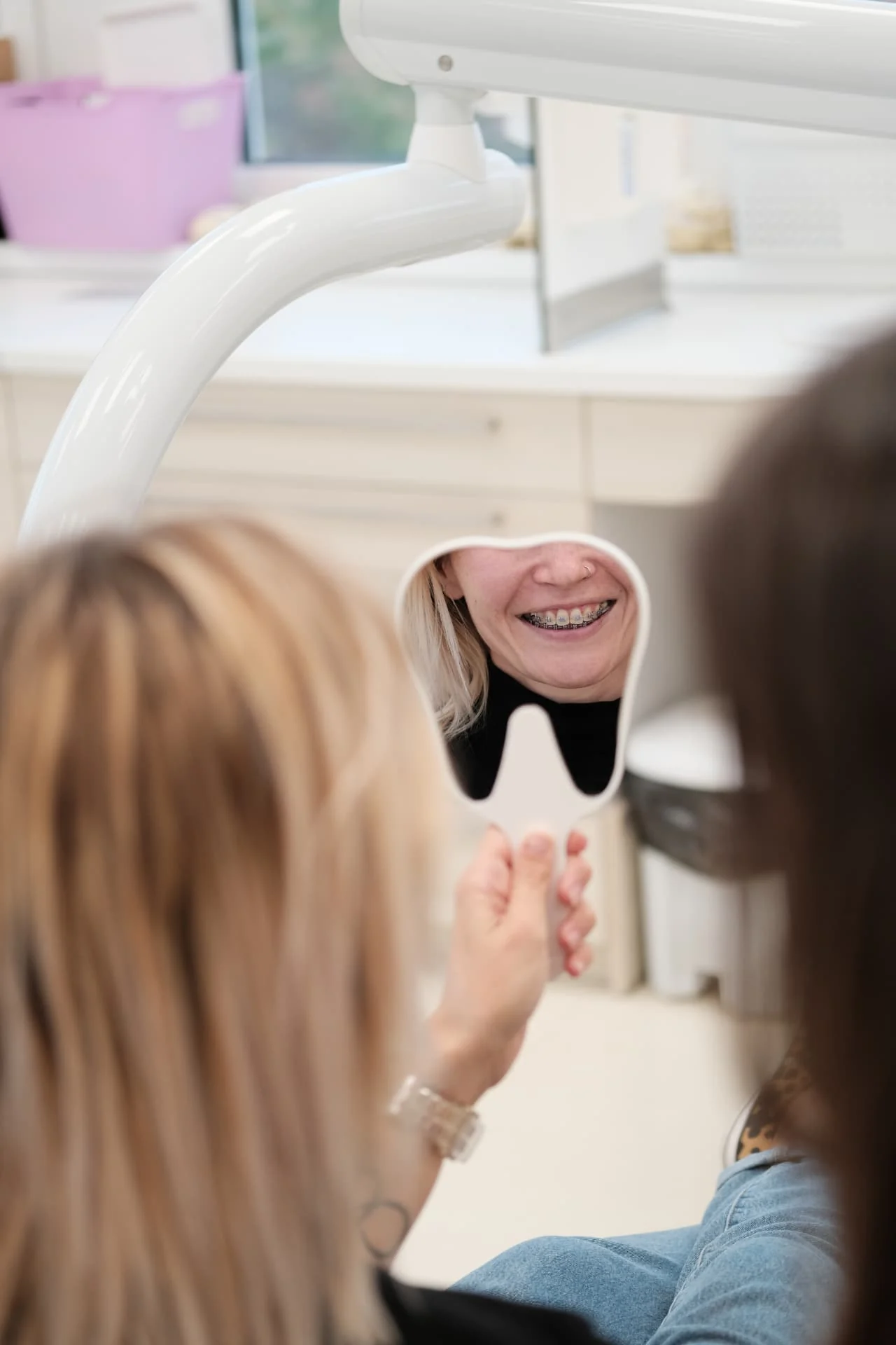 Páciens fogszabályozási eredményét nézi tükörben az Orim Dental pécsi rendelőjében
